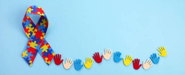 Autism awareness concept with colorful hands on blue background. Top view.